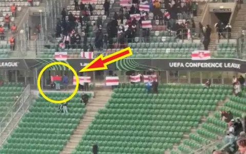 Widzimy jak wygląda flaga Legii: zielono-czerwono-zielona. Kibice na trybunach, część z nich trzyma biało-czerwone flagi.